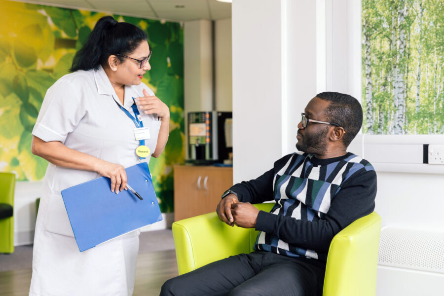 A Research Healthcare Assistant (HCA) talking to a participant at the CRDC.